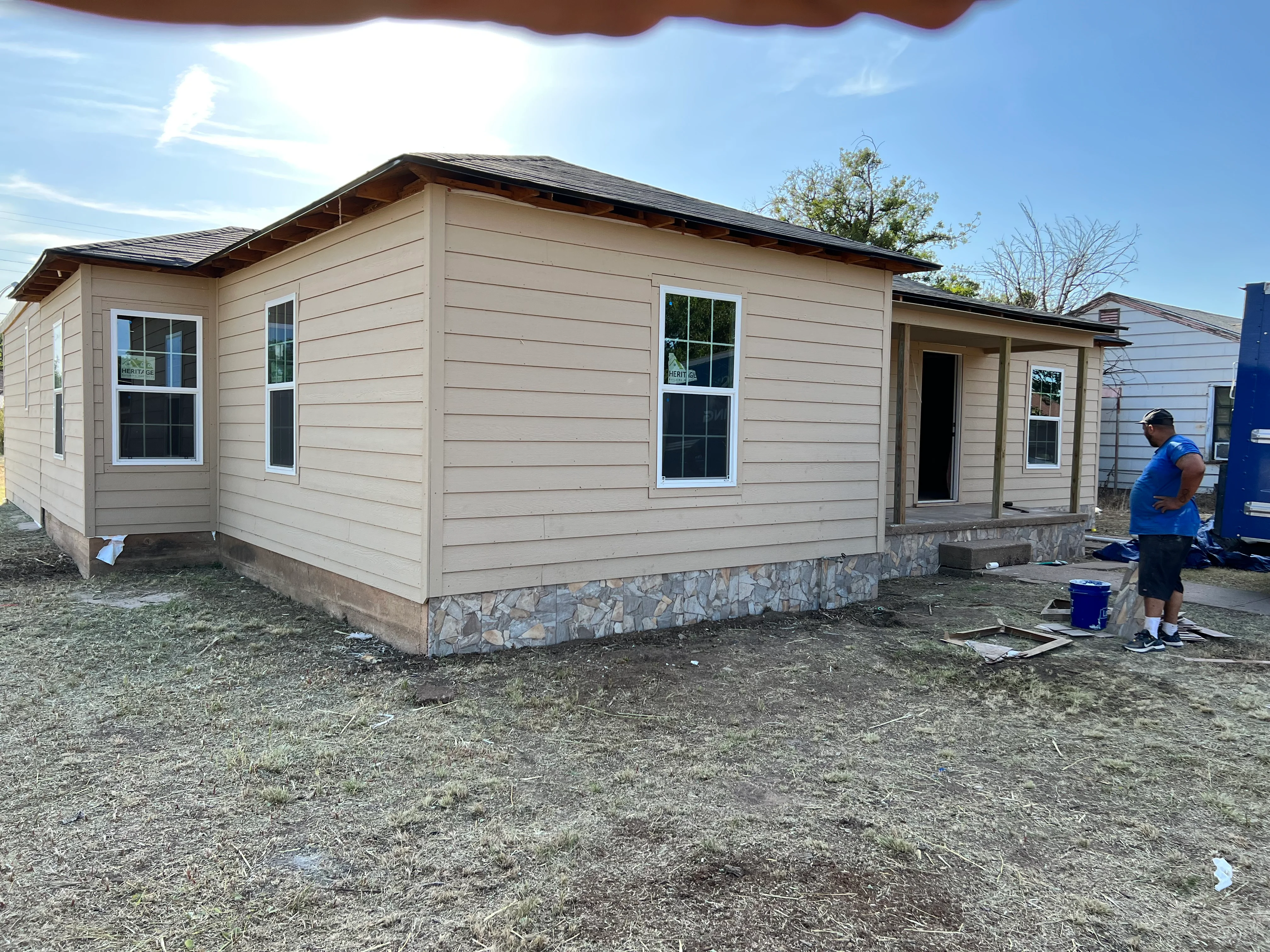 Newly renovated mobile home with tan siding, stone foundation, and modern windows in Spring, TX