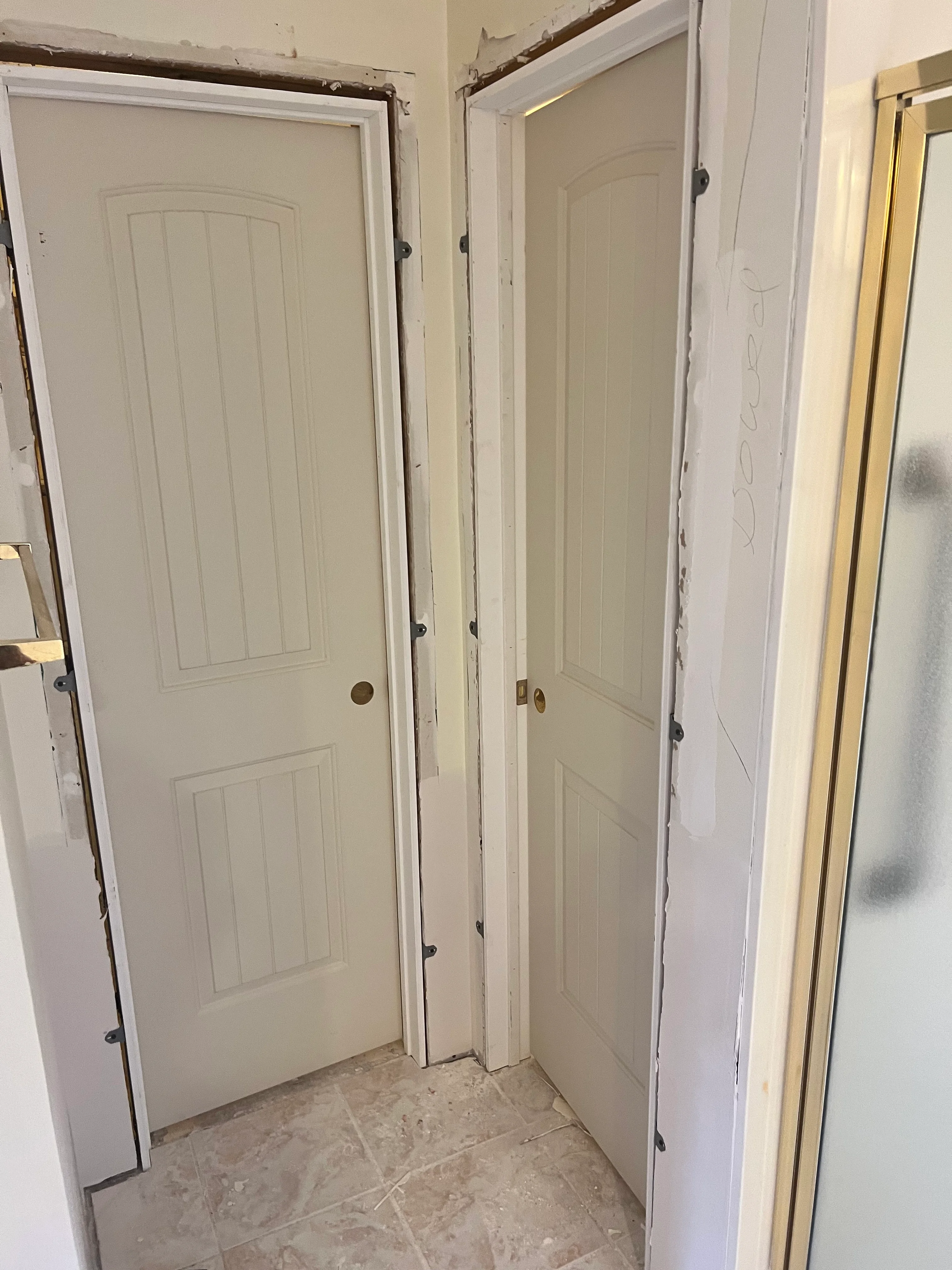 Three white six-panel interior doors installed in hallway with brass knobs