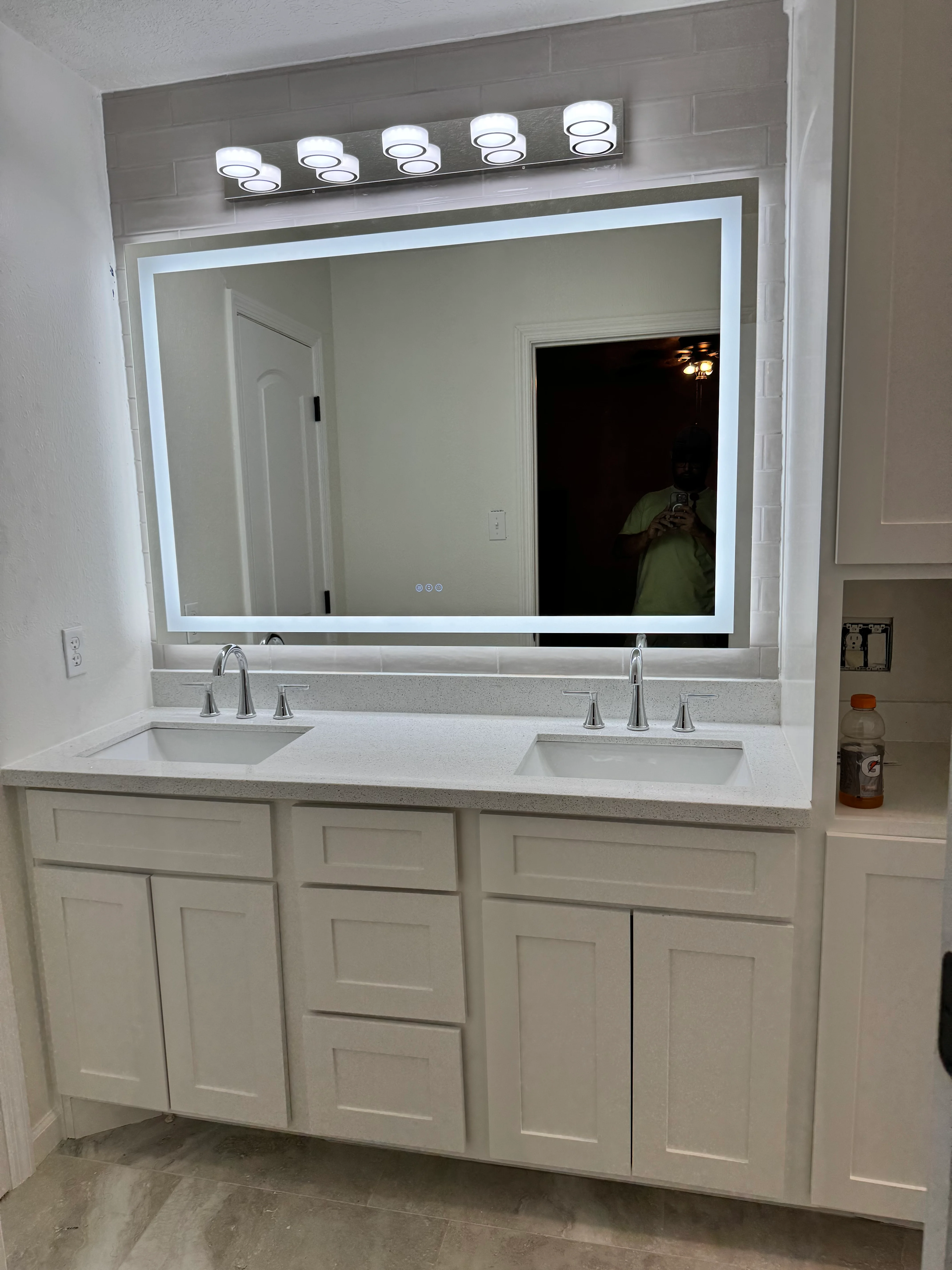 Modern dual-sink bathroom vanity with LED-backlit mirror and white cabinetry