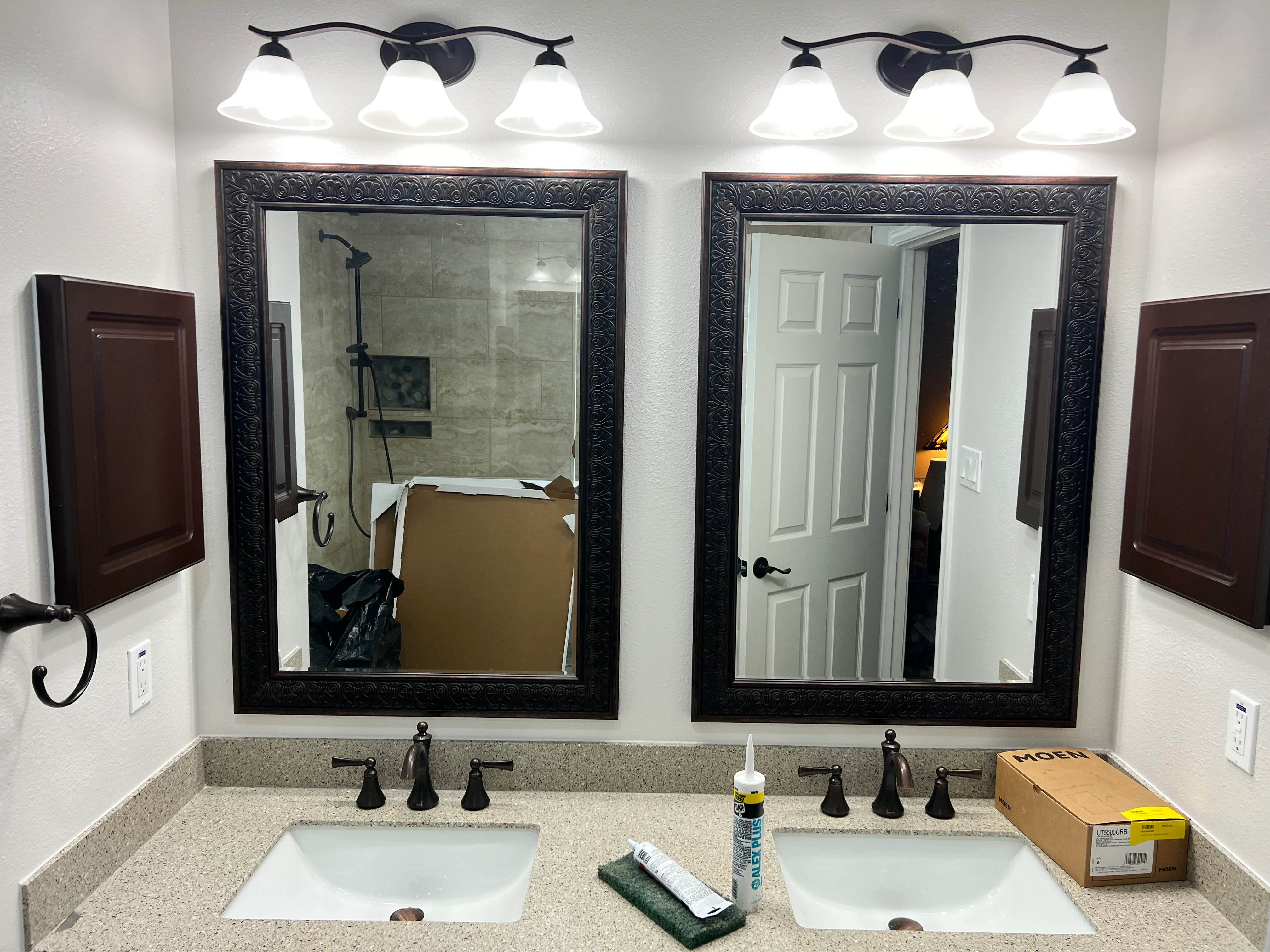Dual vanity bathroom with quartz counters, framed mirrors, and bronze fixtures