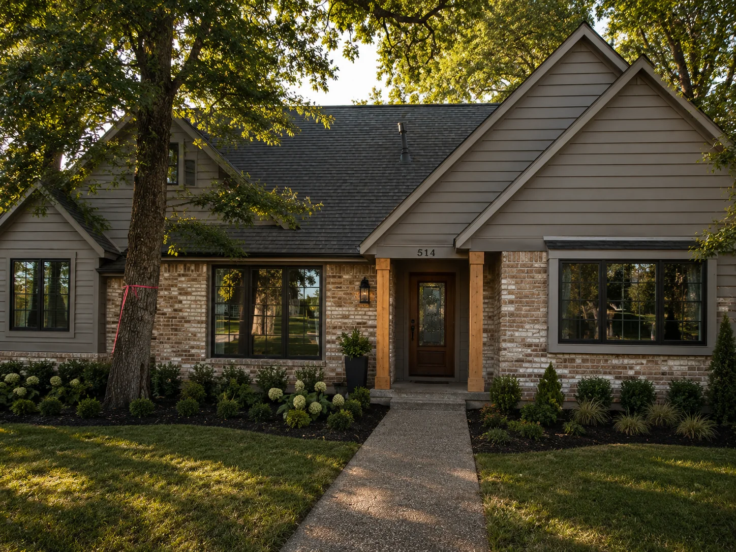 Modern brick home with gray siding, new roof, wood entry columns, and manicured landscaping