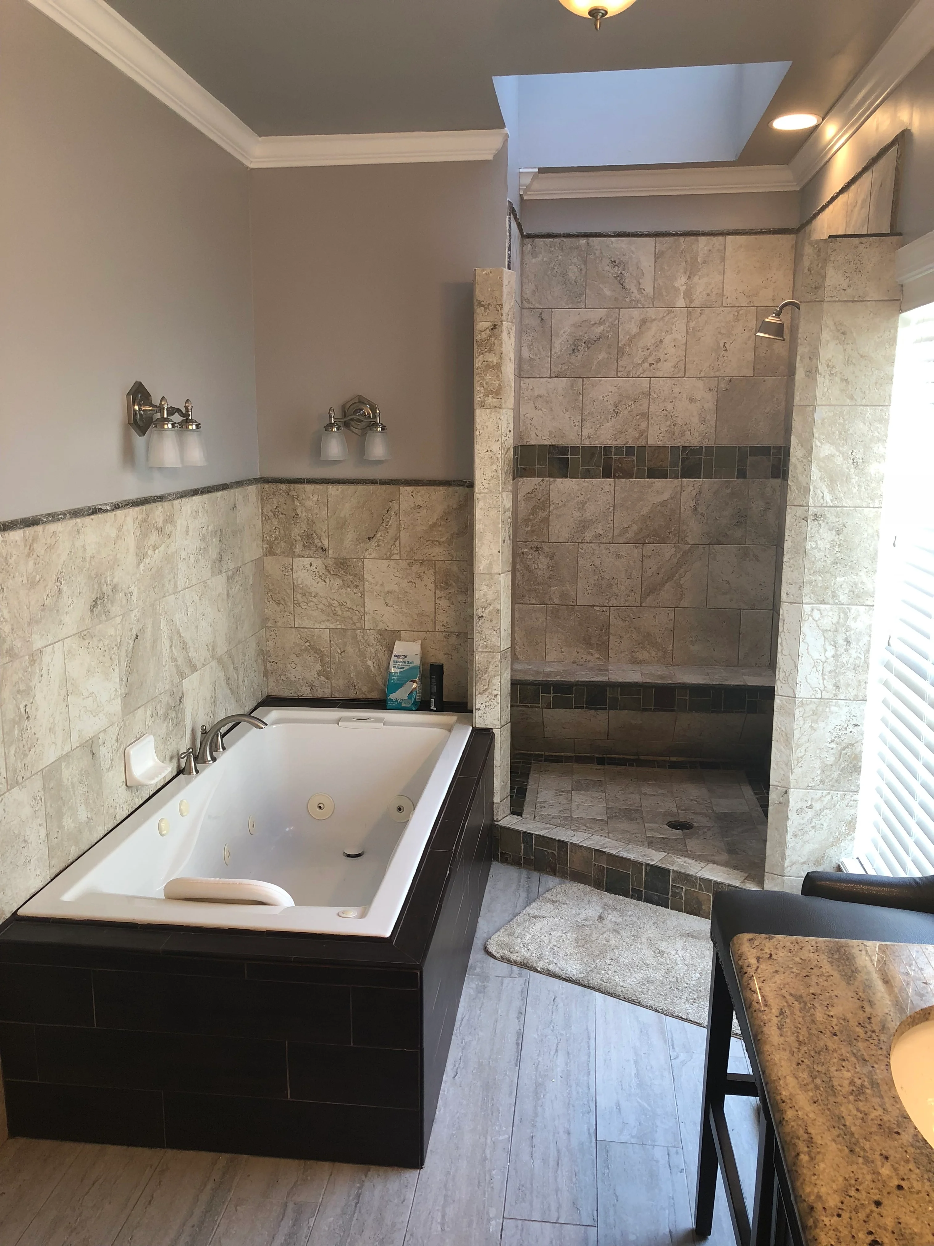 Master bathroom with white soaking tub and large tiled shower enclosure