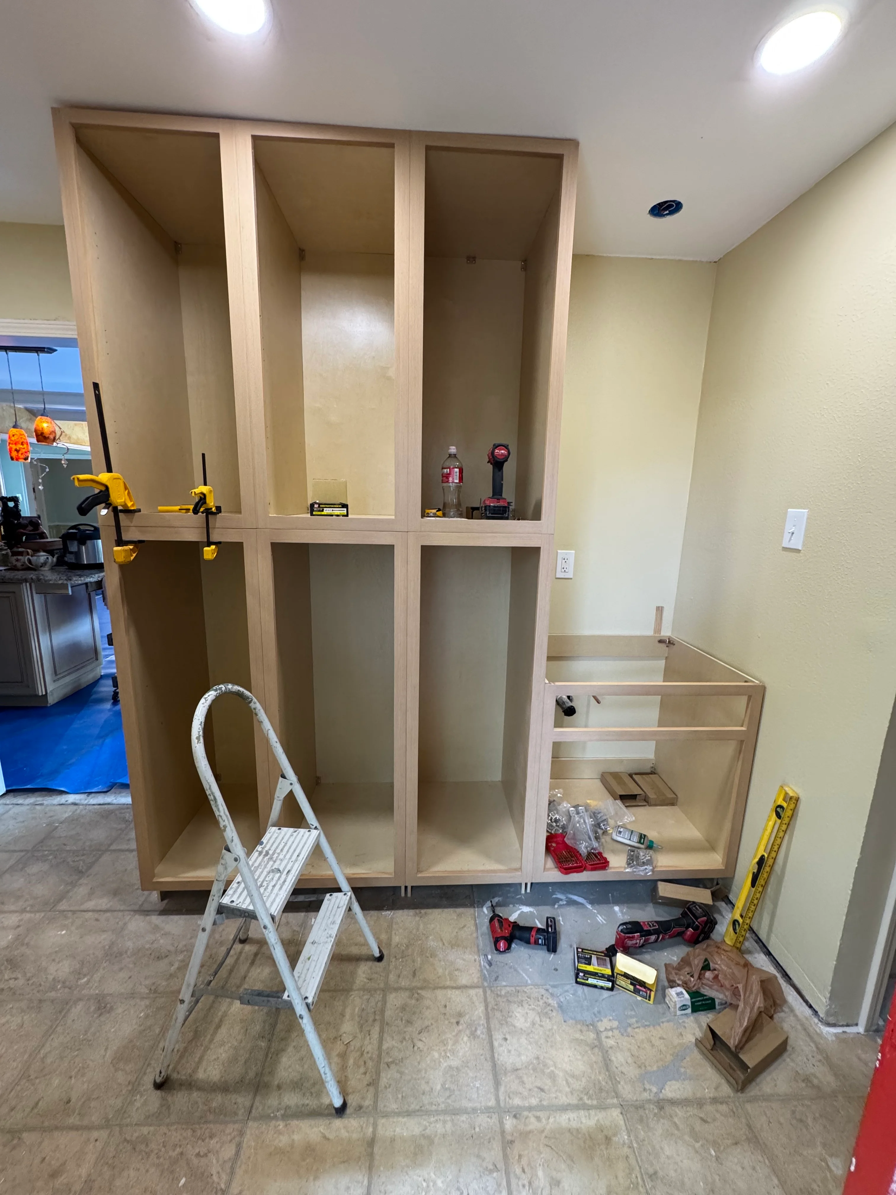 Custom wooden built-in cabinetry with six compartments and adjustable shelving during installation