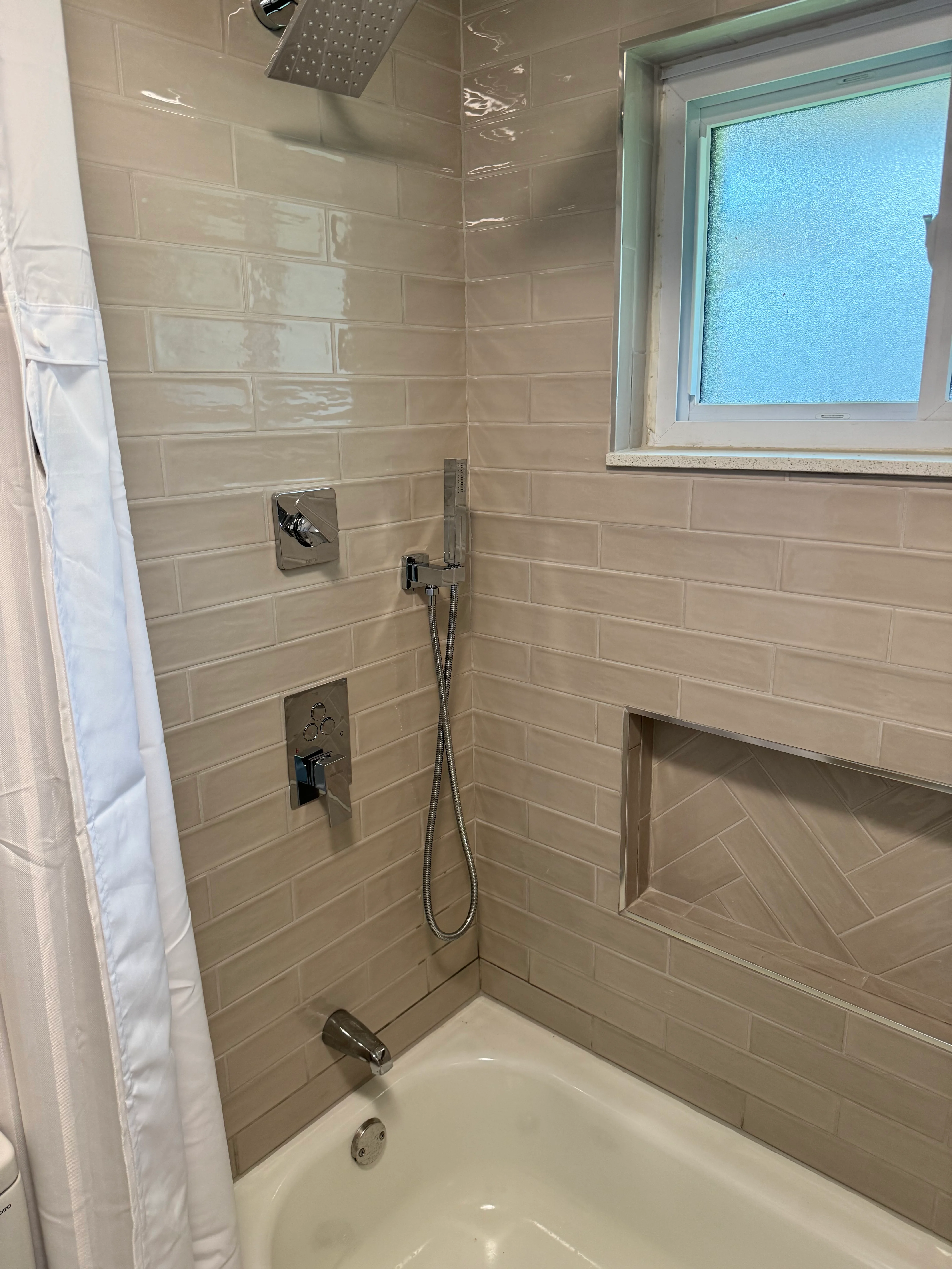 Modern shower with taupe subway tile, dual showerheads, and chrome fixtures