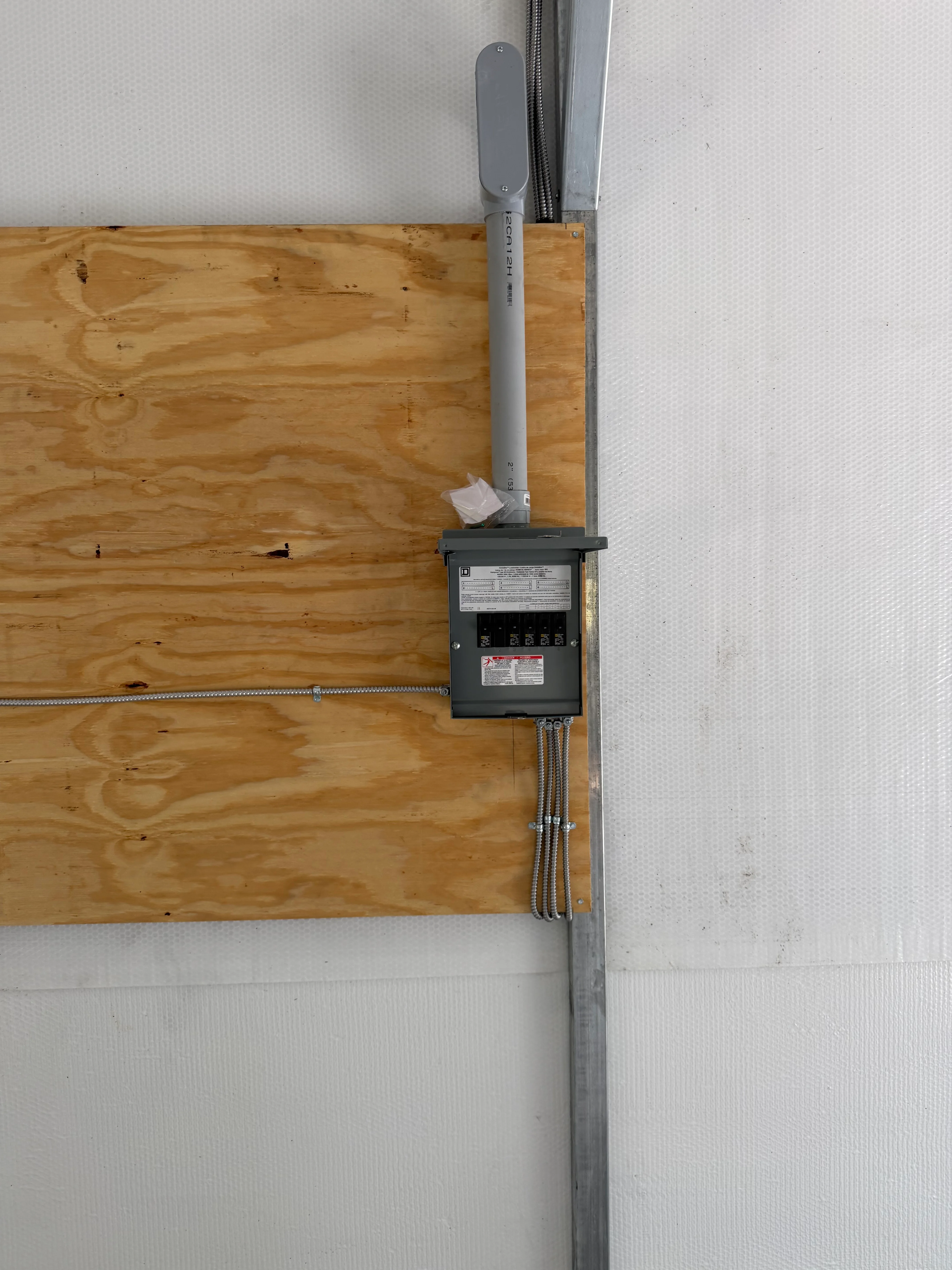 New electrical panel with breaker box, service mast, and conduit wiring installation