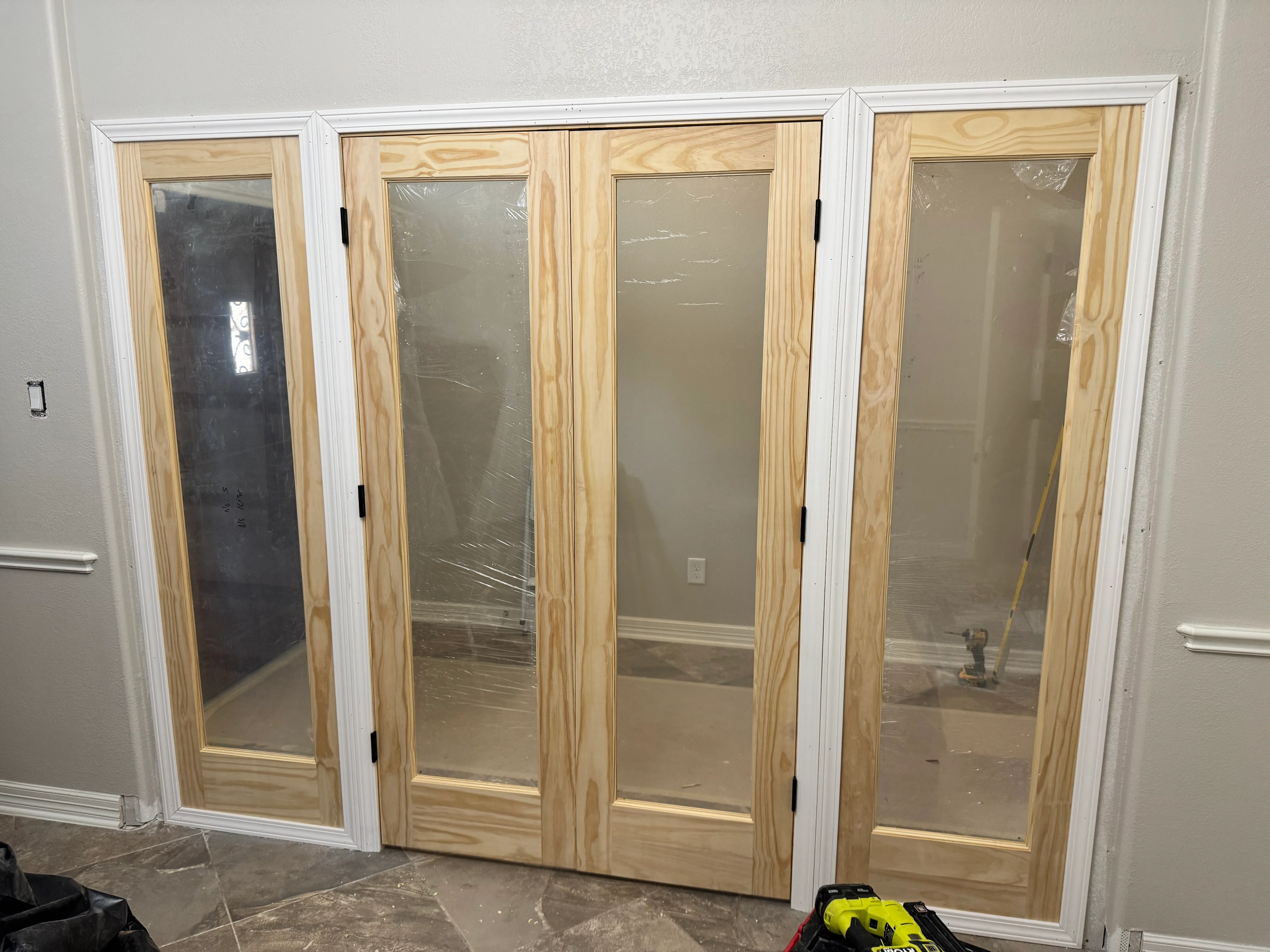 Four French doors with pine frames and white trim installed in interior wall