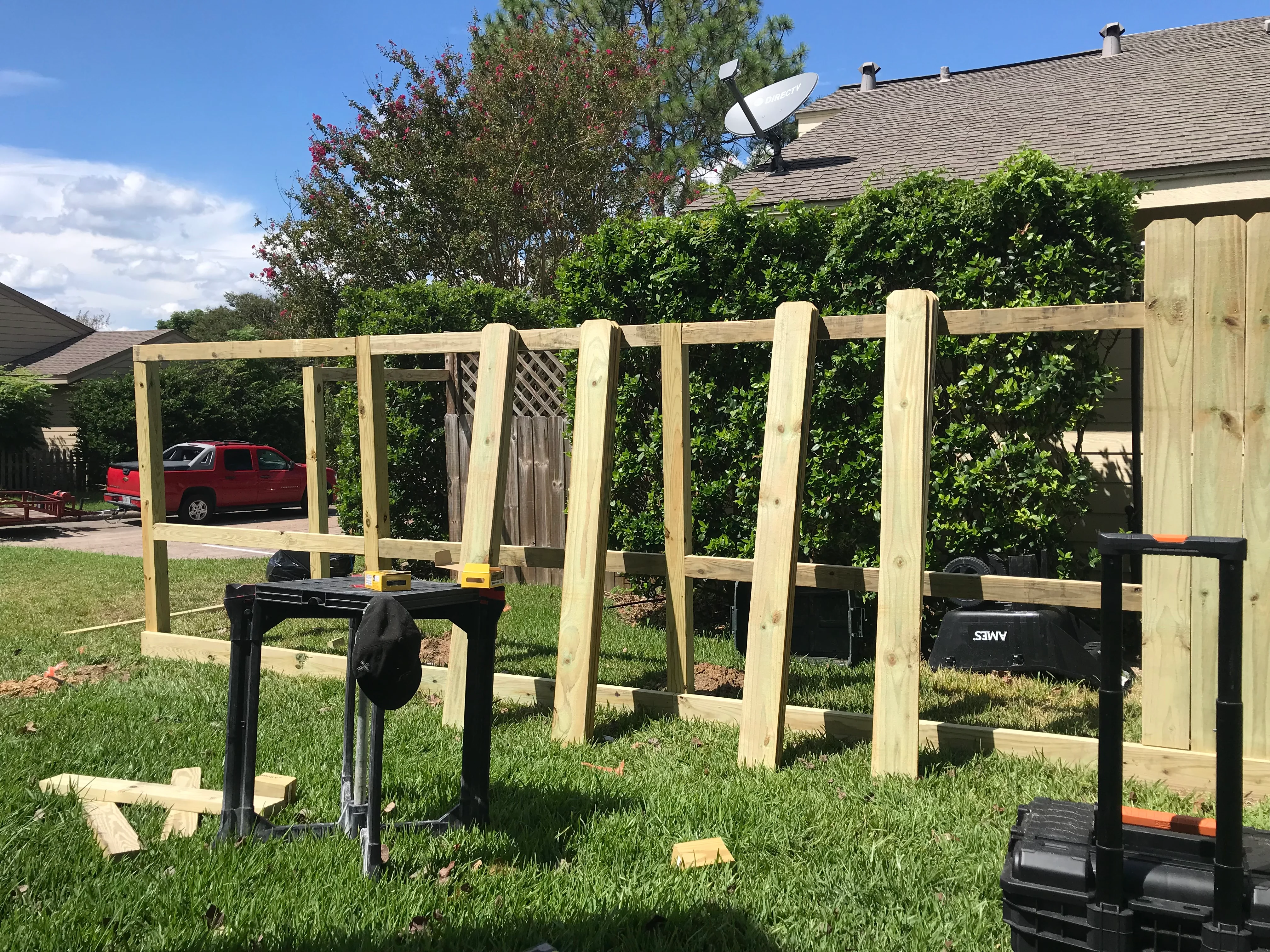 Newly constructed wooden pergola with lattice panels in residential backyard