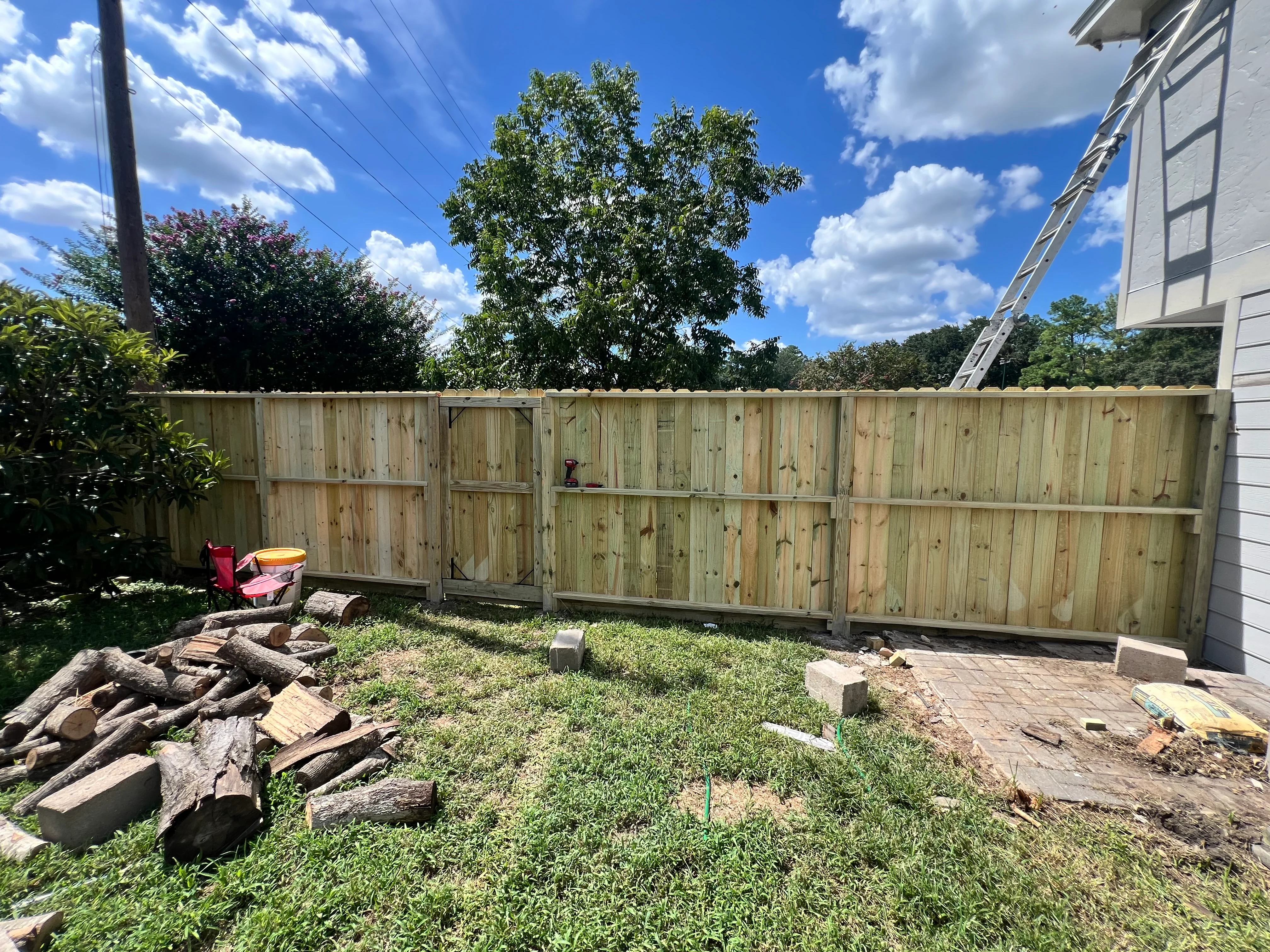 Newly installed wood privacy fence with vertical boards in residential backyard