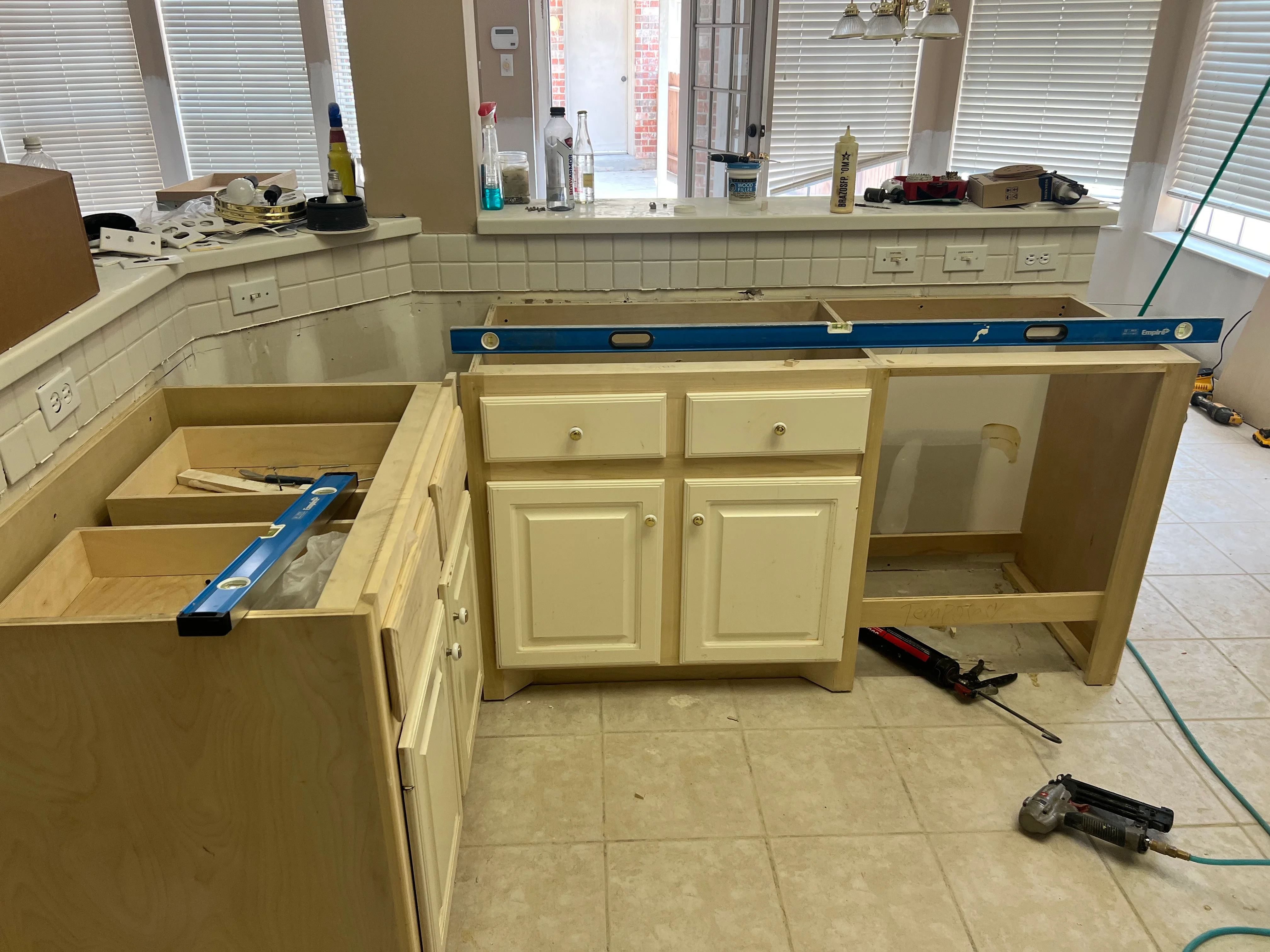 Kitchen remodel with cream cabinets, subway tile backsplash, and countertop prep in progress