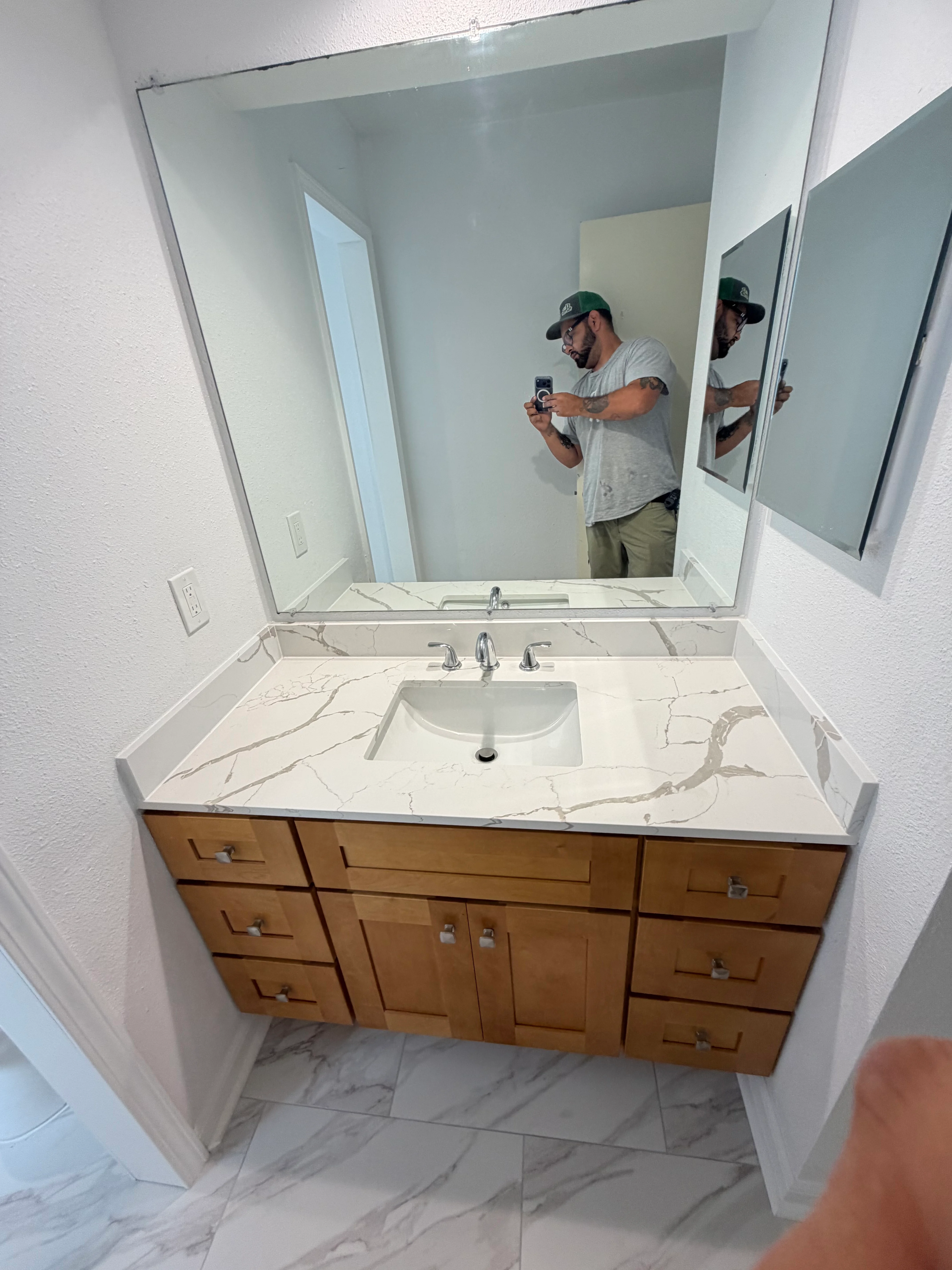 Newly remodeled bathroom vanity with marble quartz countertop and wood cabinetry