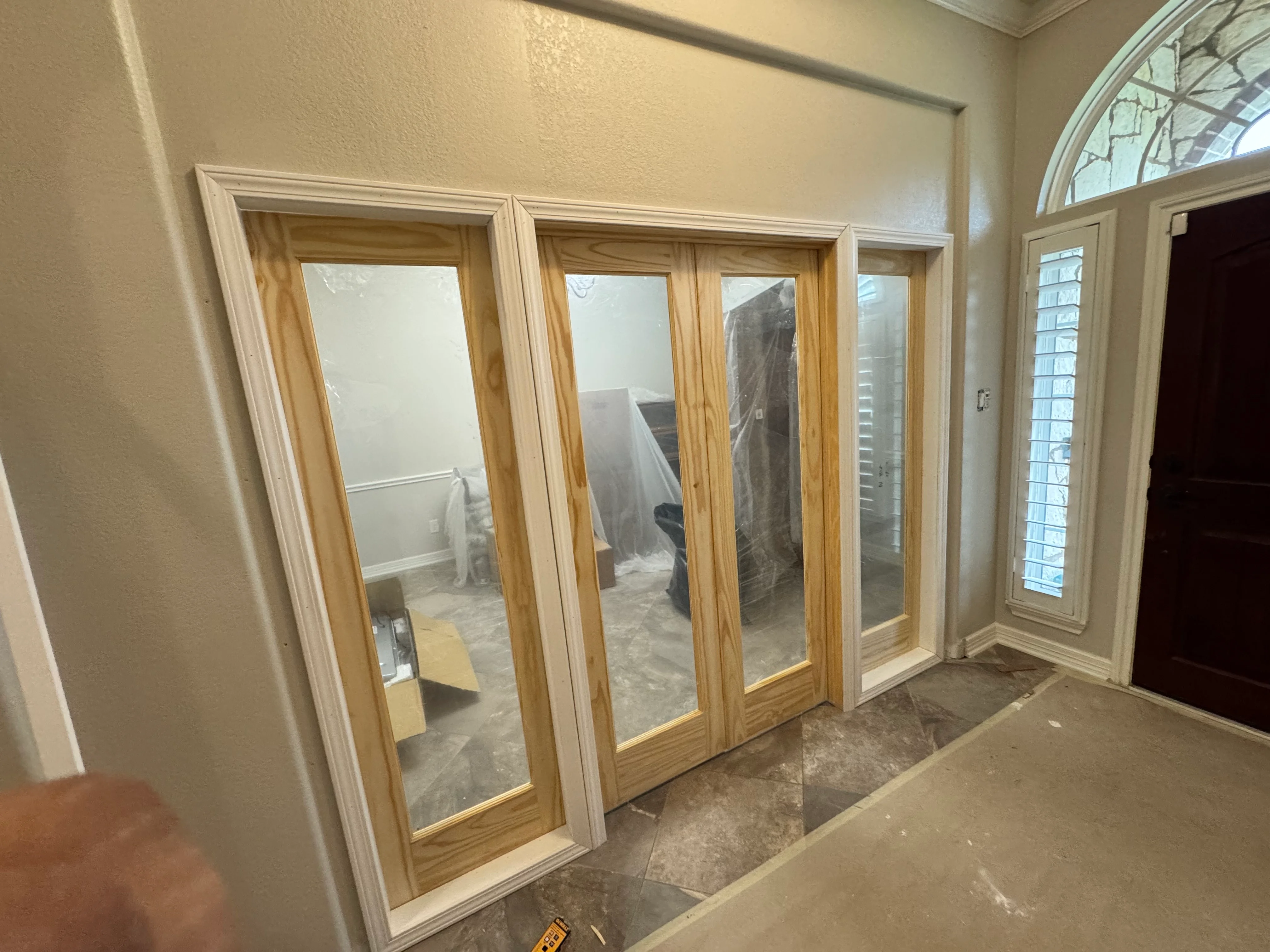 Four wood-framed glass interior doors with white trim installed in home entryway