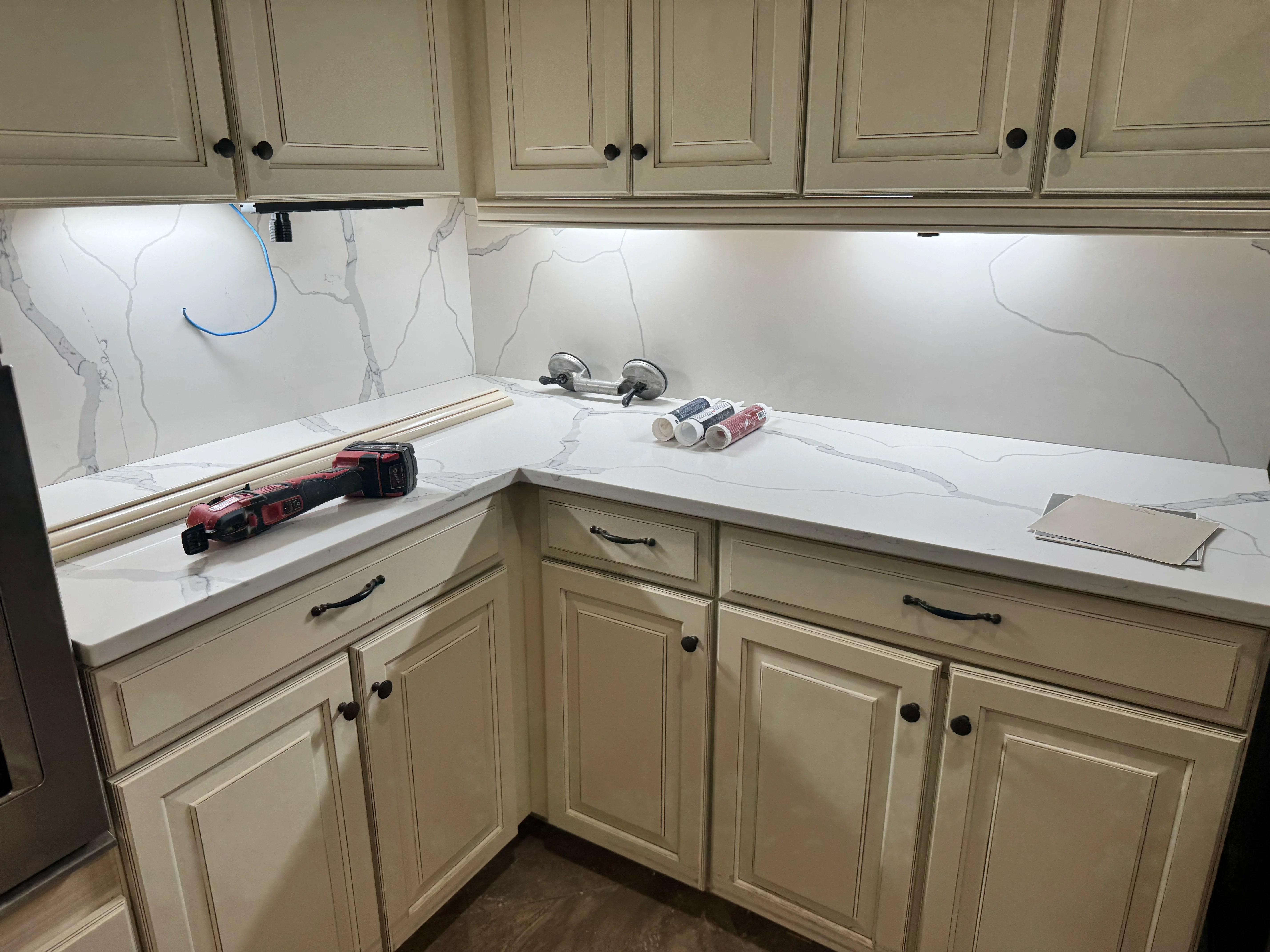 White marble quartz countertops with gray veining installed in kitchen with cream cabinets