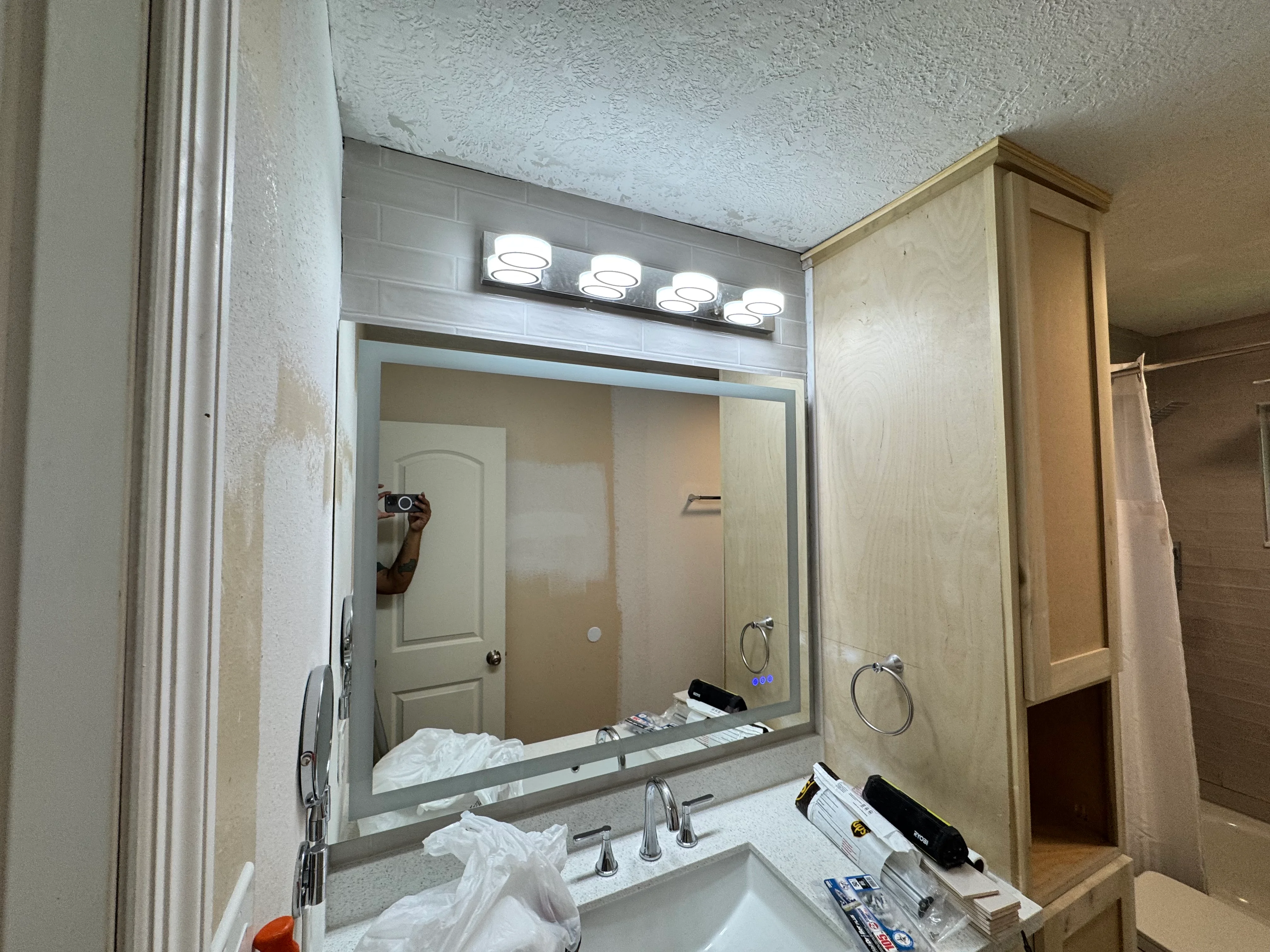 Modern bathroom vanity with framed mirror, LED lighting, and granite countertop